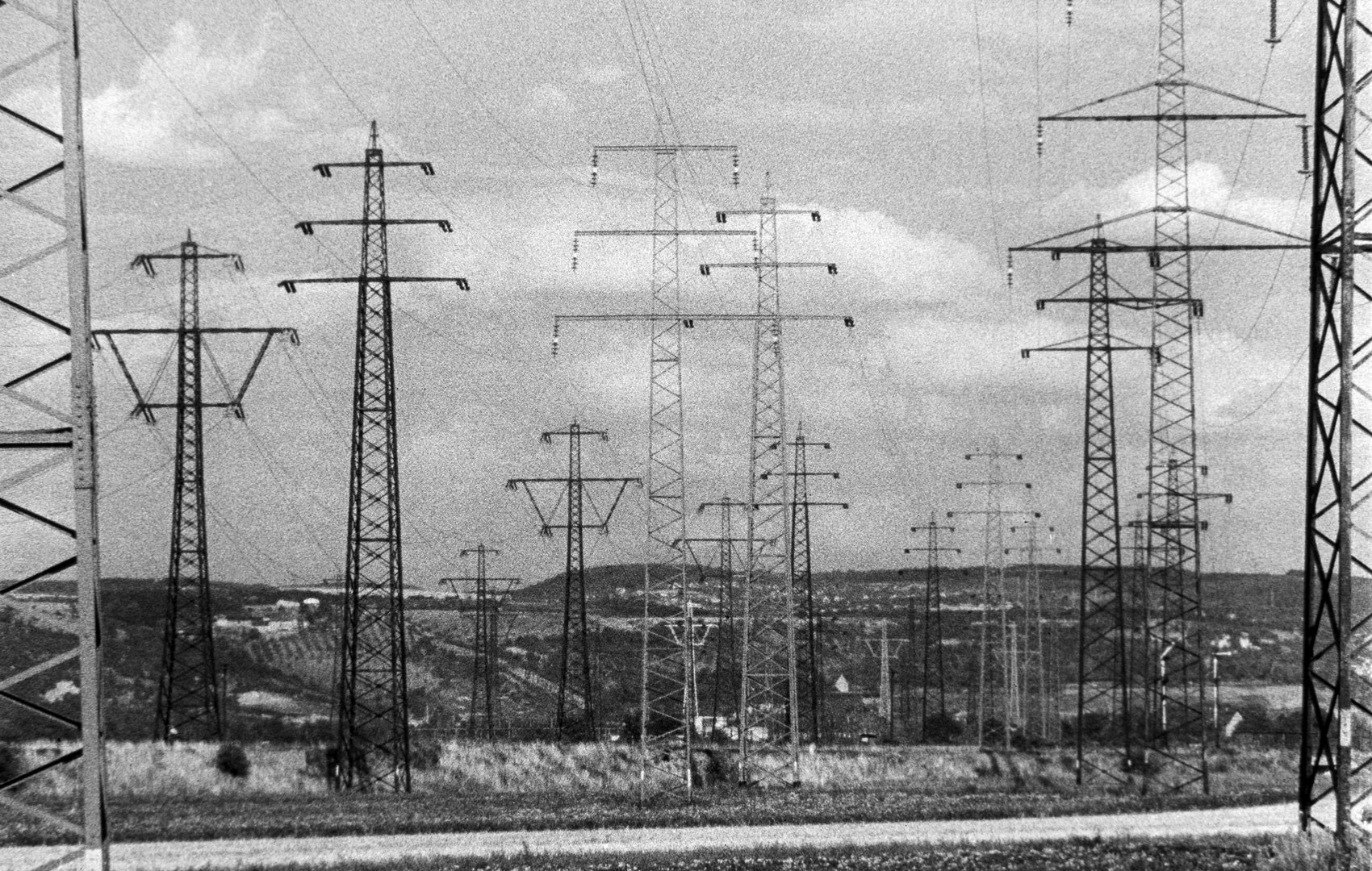 Schwarz-Weiß-Bild: Eine Landschaft voller Strommasten.