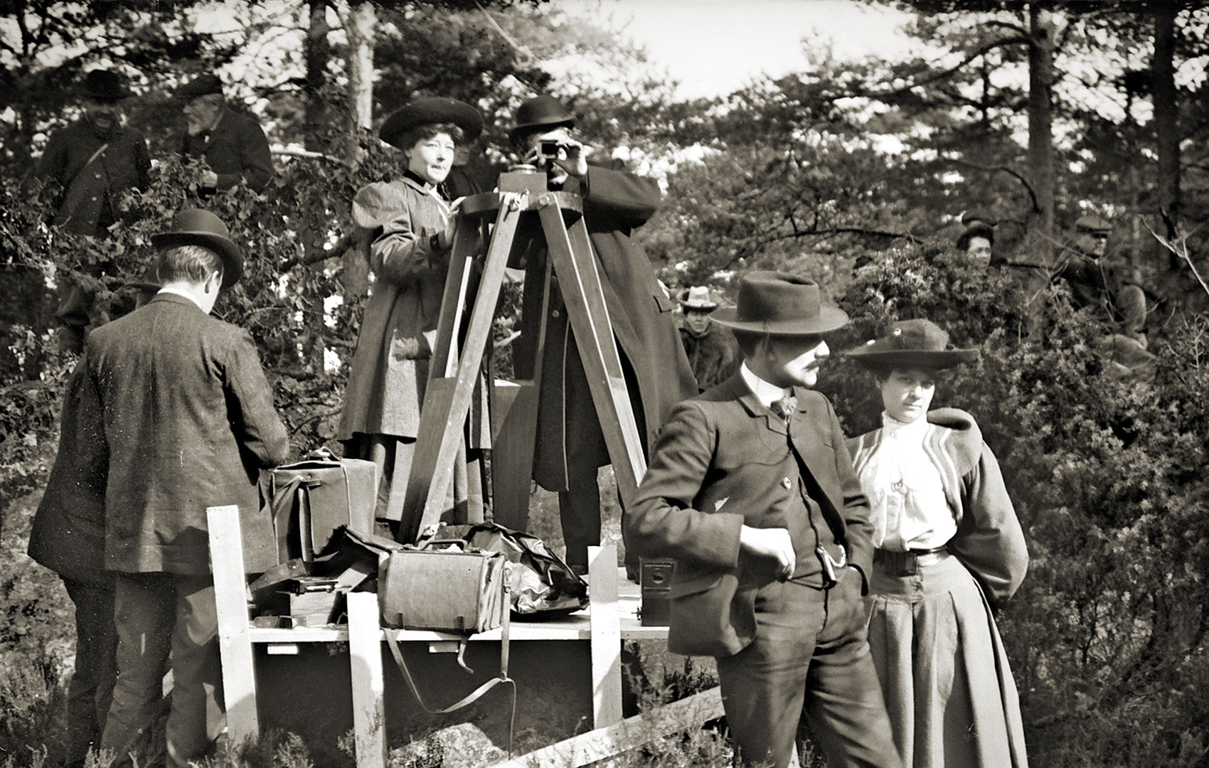 Schwarz-Weiß-Bild mit Filmteam Anfang des 20. Jahrhunderts. An der Kamera steht eine Frau.