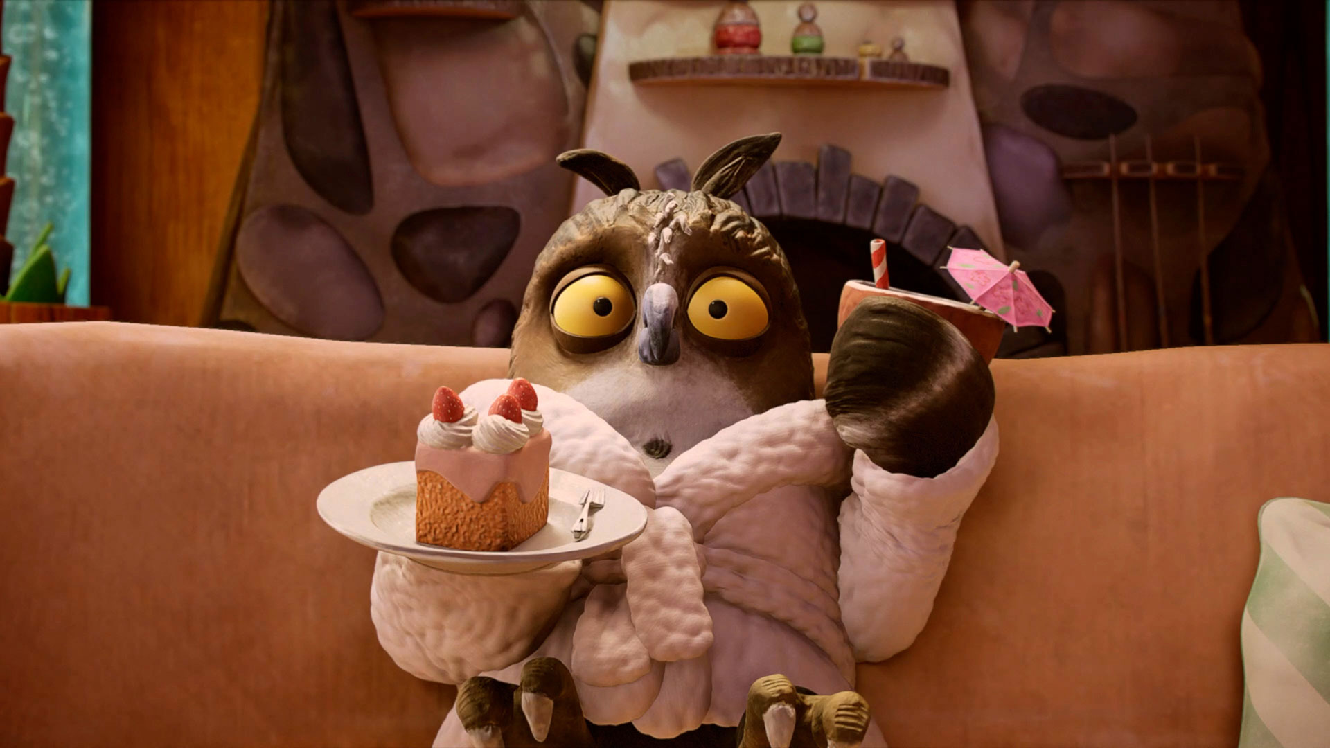 2026_slider_anmeldestart Eine Eule im rosa Bademantel sitzt auf der Couch. In der einen Hand hält sie einen Teller mit einem Stück Torte, in der anderen einen Becher mit Strohhalm und Schirmchen.